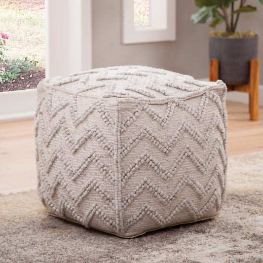 a white cube shaped pouf on a rug